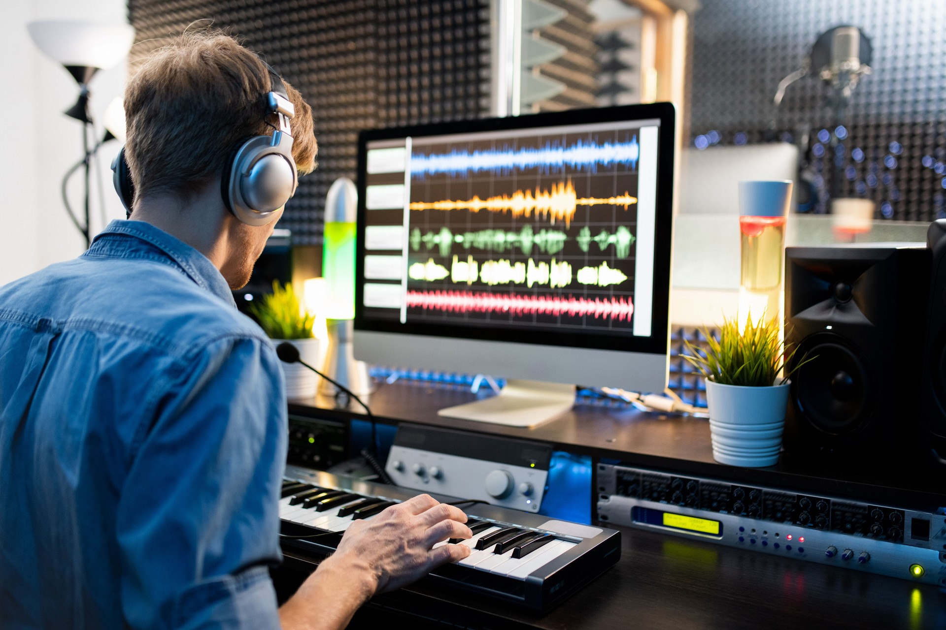 Musiker mit Kopfhörerdrücken der Klaviertastatur per Computerbildschirm
