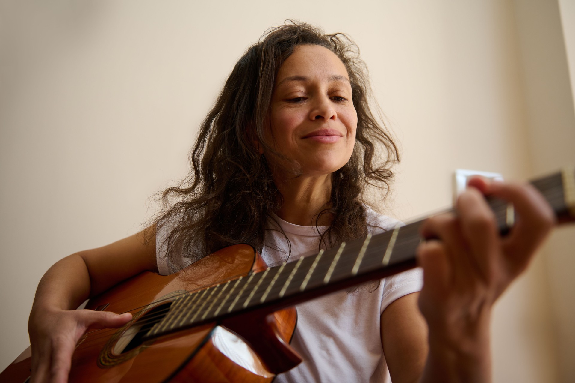 Frau spielt Akustikgitarre in entspannter und besinnlicher Stimmung